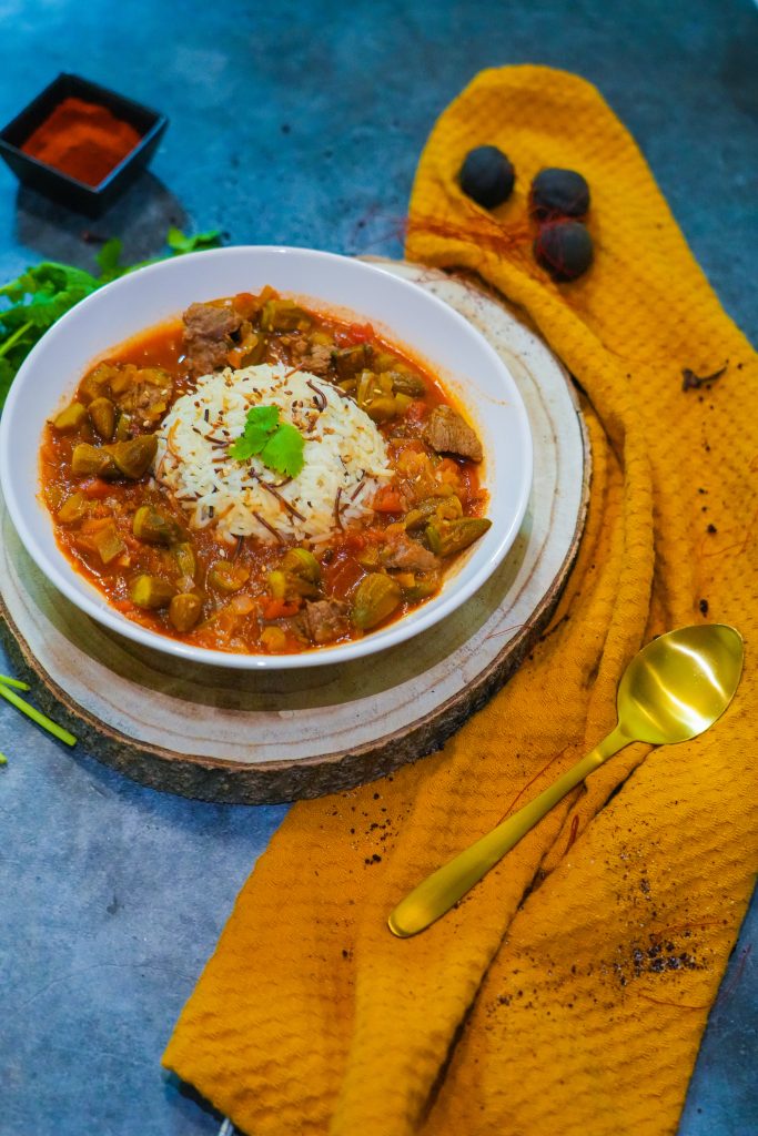 Orientalischer Okraeintopf mit zartem Gulasch und Gewürzen, serviert in einer tiefen Schale mit frischem Koriander dekoriert.