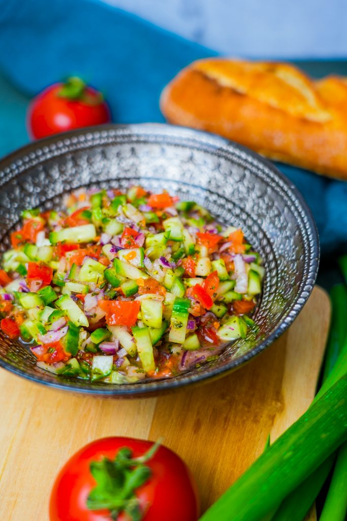 Shirazi Salat: Erfrischender persischer Salat aus Tomaten, Gurken, Zwiebeln, Zitrone und Olivenöl, dekoriert mit Minze.
