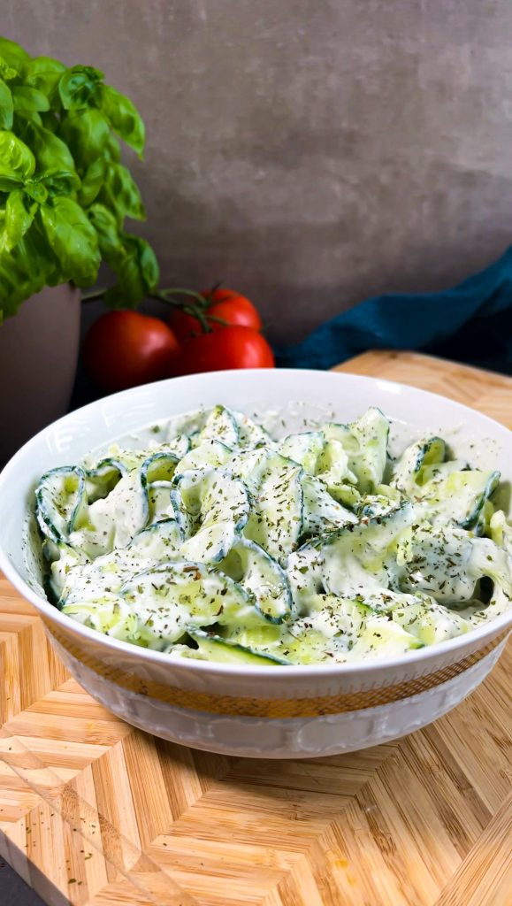 Frischer Gurkensalat in dünnen Streifen, mit cremigem Joghurt, Minze und Knoblauch, angerichtet in einer Schüssel.